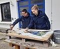 Die Bufdis Nicola (OV Augsburg) und Patrick (OV SMÜ) beim Vorbereiten der Plakate für den Schwabmünchner Blaulichttag. (Bild: Anna-Sophie Haas, THW)