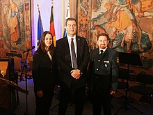Ministerpräsident Dr. Markus Söder (Mitte) mit unserer Helferin Sarah Seebach und unserem Helfer Oliver Teynor beim Staatsempfang in München (Bild: THW Augsburg)