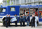 Feierliche Übergabe des Spendenschecks vor der Wohnanlage für Baustudierende in Augsburg (Bild: THW-Helferverein Augsburg)