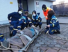 Das Binden einer verletzten Person auf eine Trage (Bild: Eunike Sailer/THW Augsburg)