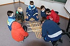 Gemeinsam versuchen unsere Kinder aus Holzteilen und ohne weitere Hilfsmittel eine Brücke zu bauen (Bild: Dieter Seebach/THW Augsburg)